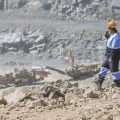 Worker in protective uniform supervising mining operations at a quarry site