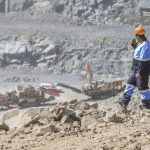 Worker in protective uniform supervising mining operations at a quarry site